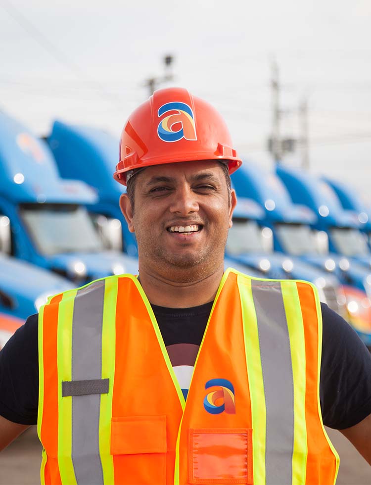 Amar driver standing beside Amar trucking cab