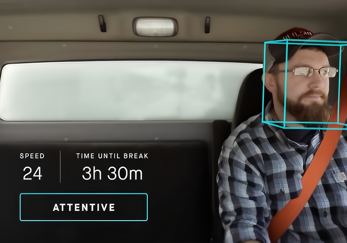 Amar truck driver wearing seatbelt in driver’s seat with overlaid metrics about their speed, time until break, driving evaluation