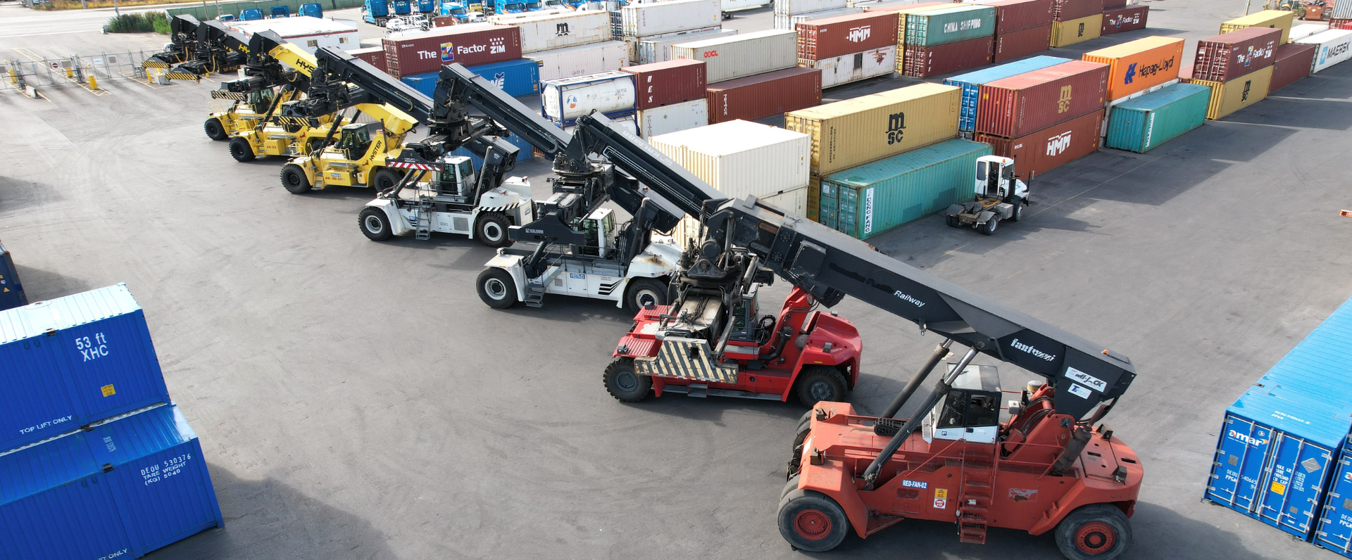 Lineup of reach stacker cranes parked in Amar container yard