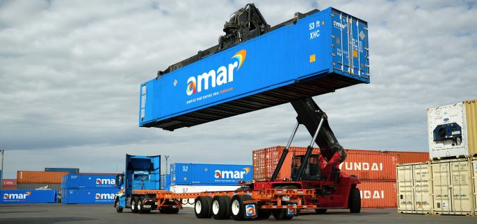 Amar Group reach stacker crane listing Amar-owned freight container off chassis to be stored in container yard