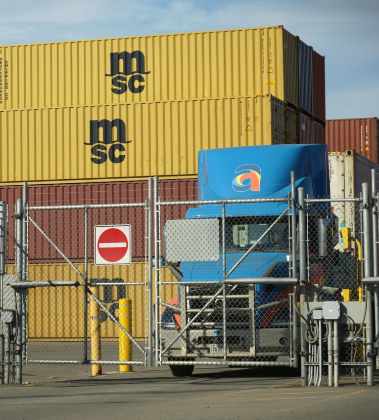 Amar truck transporting freight approaching container yard exit gate